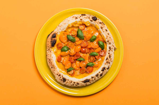Pizza w stylu nowoczesnym z sosem żółtych pomidorków z pomidorkami koktajlowymi i bazylią 