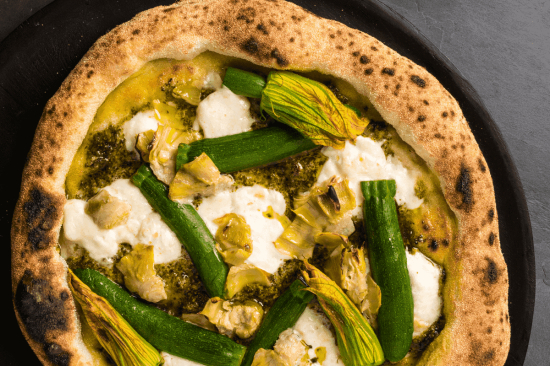 Pizza wegetariańska w stylu nowoczesnym z sosem pomidorowym, cukinią baby, groszkiem, pomidorkami 